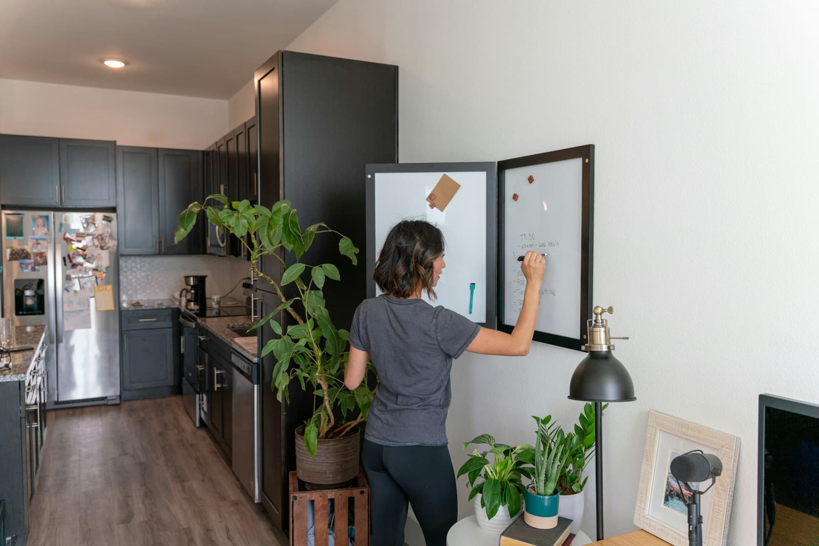 Woman caring for a bright kitchen—checking the refrigerator during detailed cleaning