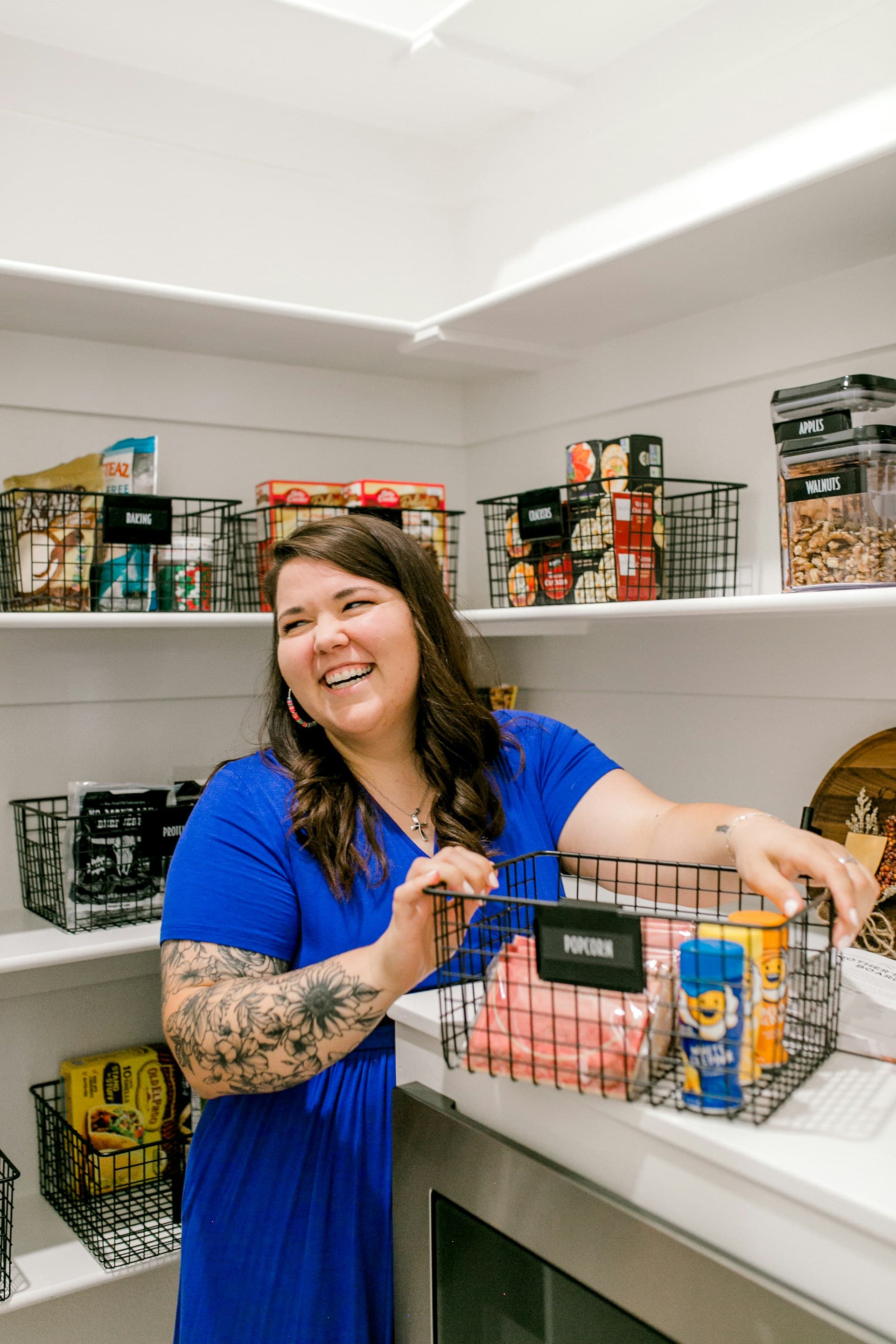 Woman arranging items on tidy pantry shelves during an in-home organization session